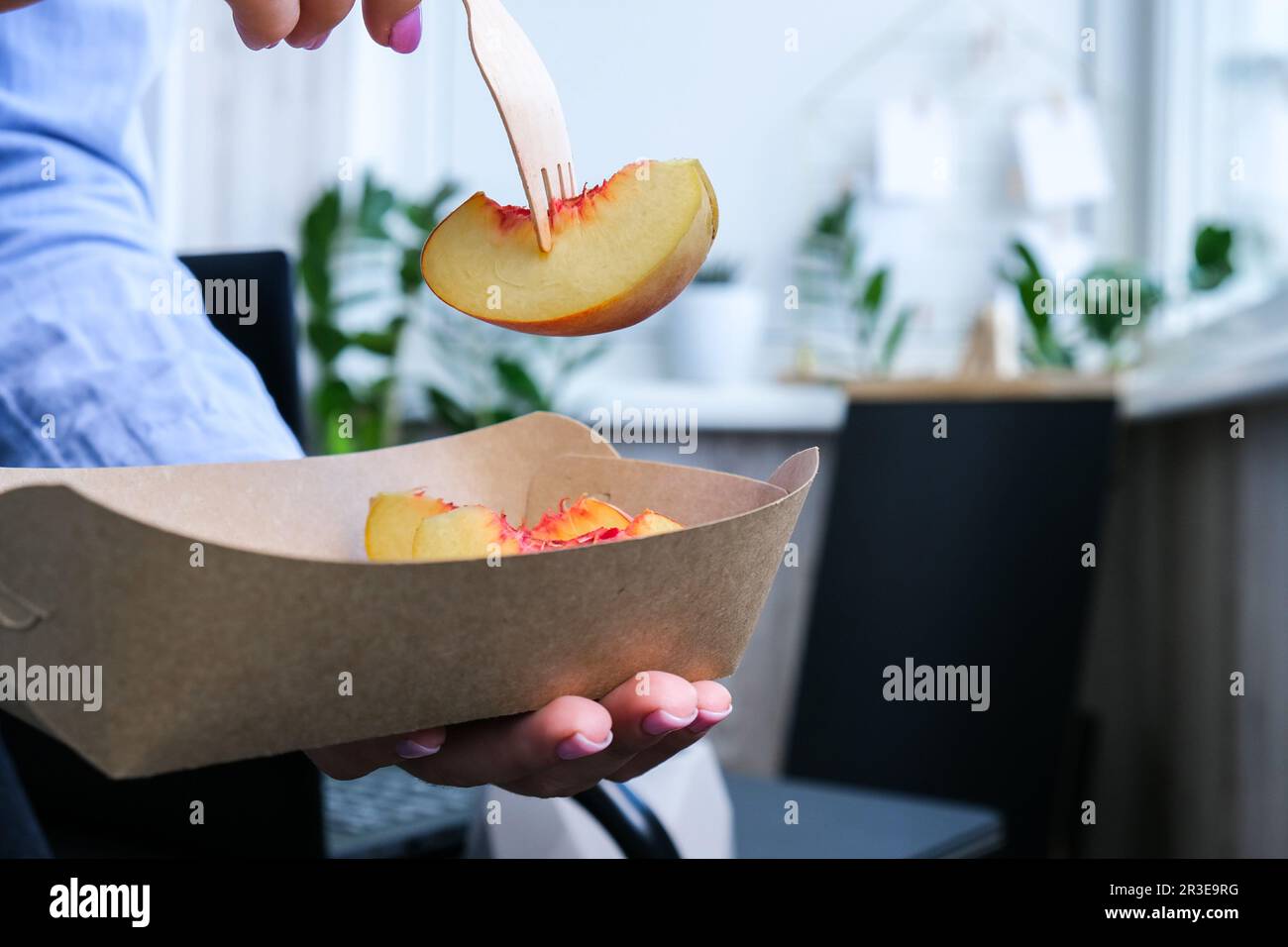 Una donna d'affari che ha una pausa pranzo sana dalle scatole da pranzo ecologiche consegnate. Delizioso concetto di cibo equilibrato. Ufficio domestico. Scheda ECO Foto Stock