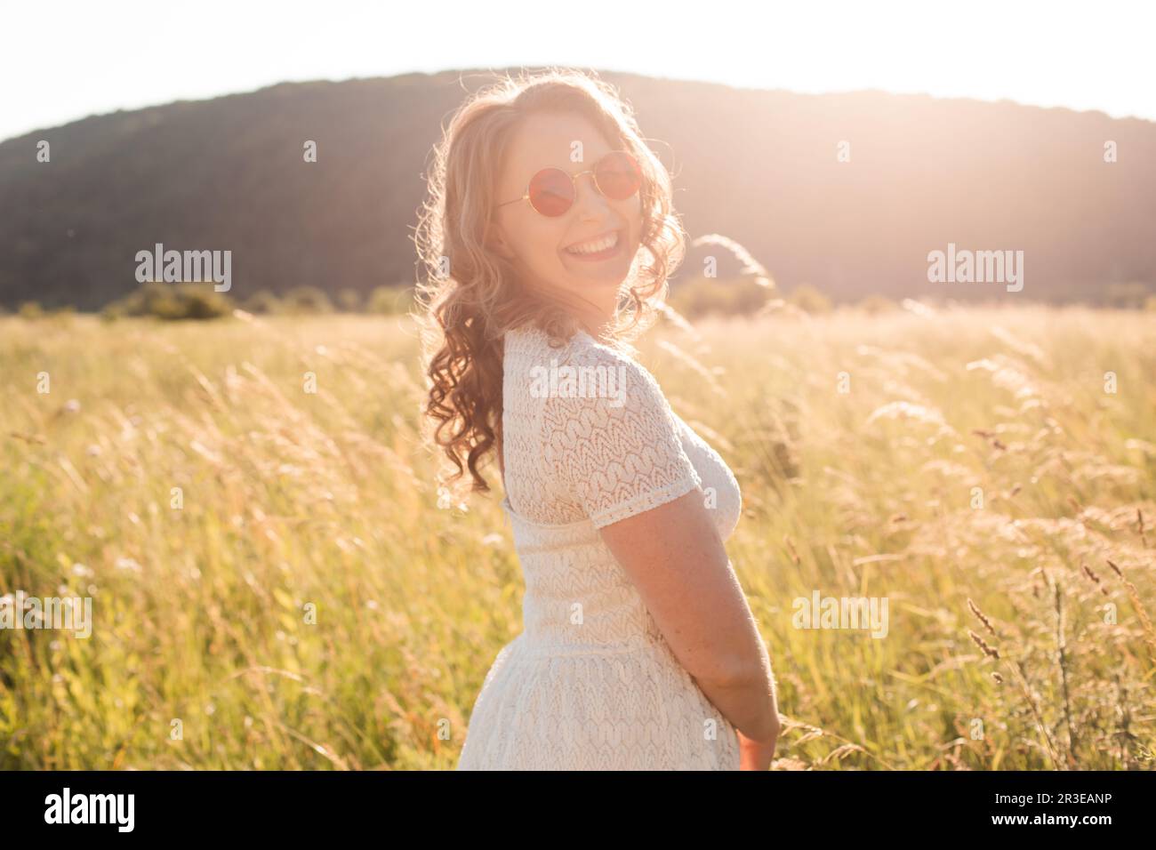 La giovane gioiosa donna in occhiali da sole delizia la natura Foto Stock