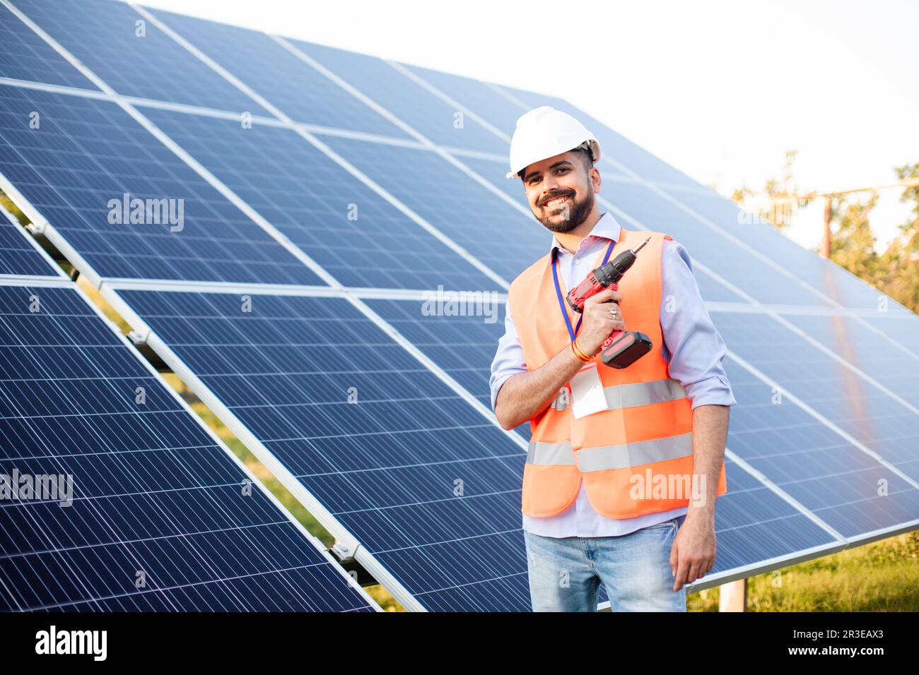 Il giovane elettricista lavora in una stazione solare Foto Stock