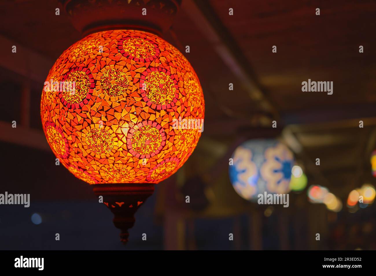 Lampada turca colorata e tradizionale rossa luminosa o lanterna fatta a mano, focalizzazione selettiva sulla lanterna, sfondo sfocato, lanterne ricordo popolari nel caffè Foto Stock