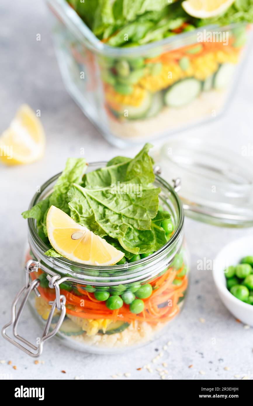 Vaso di vetro con verdure fresche crude e cuscus. Preparazione dei pasti sani - foto di preparazione delle ricette. Piatti vegani sani in Foto Stock