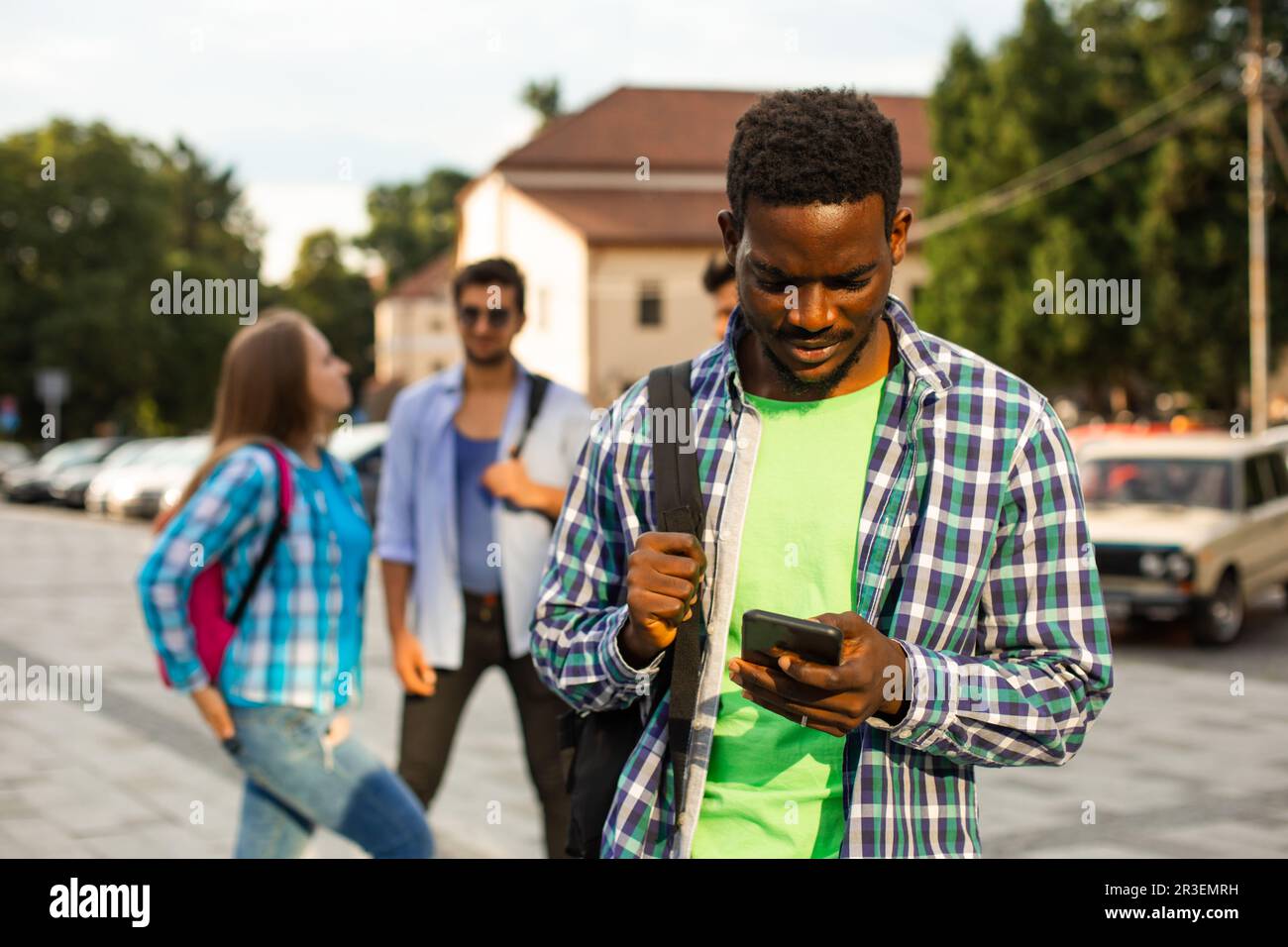 Il giovane studente africano usa la navigazione su uno smartphone Foto Stock