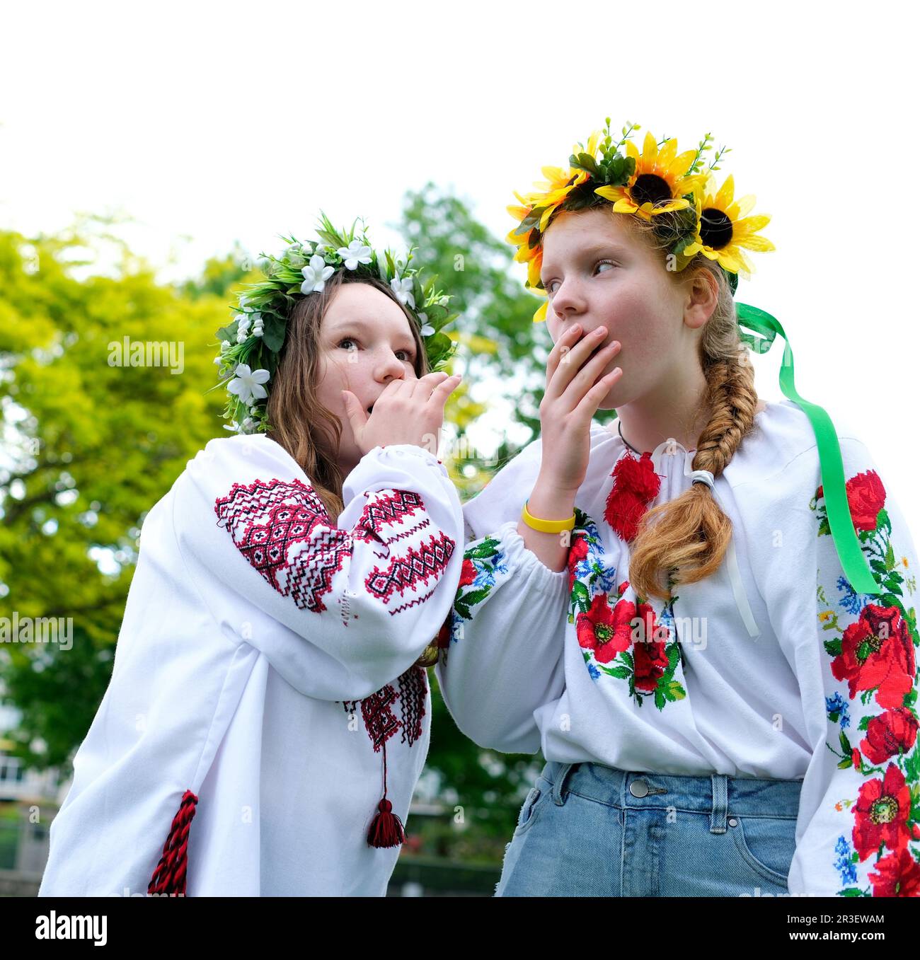 Belle giovani ragazze adolescenti giovani donne che sussurrano pettegolezzi sorpresi guardando ragazzi stare da parte sogno raccontare segreti Whispering in orecchio aprire la bocca coprire con il palmo della mano ridendo Foto Stock