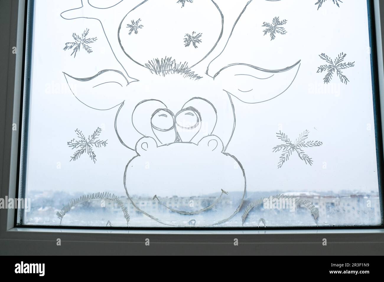 Cervi di Natale dipinto su vetro della finestra. Decorazioni invernali natalizie sul vetro della finestra. Disegno bianco di cervo. Neve arte tracery vento Foto Stock