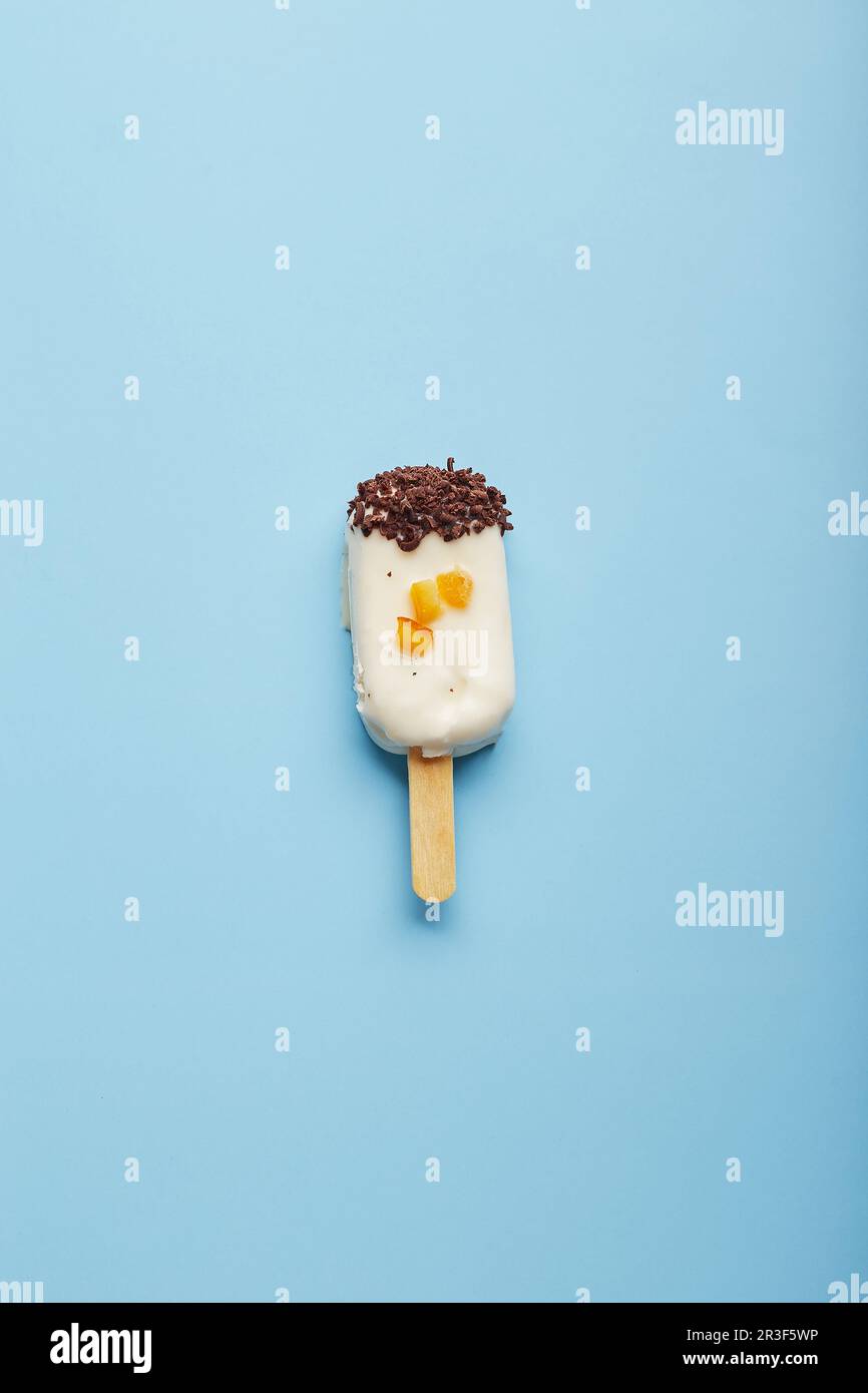 Dessert alla mousse con aromi di frutta sotto forma di gelato a forma di pop-sicle su sfondo blu. Foto Stock