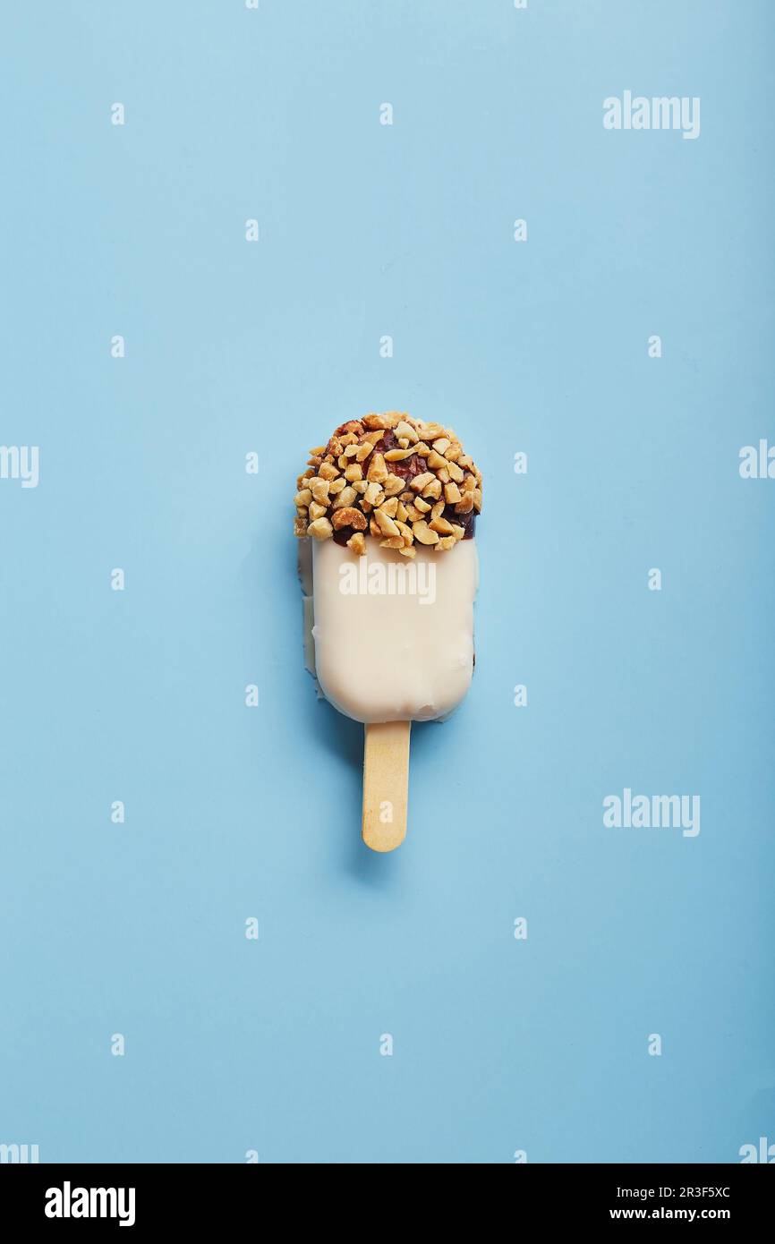 Dessert alla mousse con aromi di frutta sotto forma di gelato a forma di pop-sicle su sfondo blu. Foto Stock