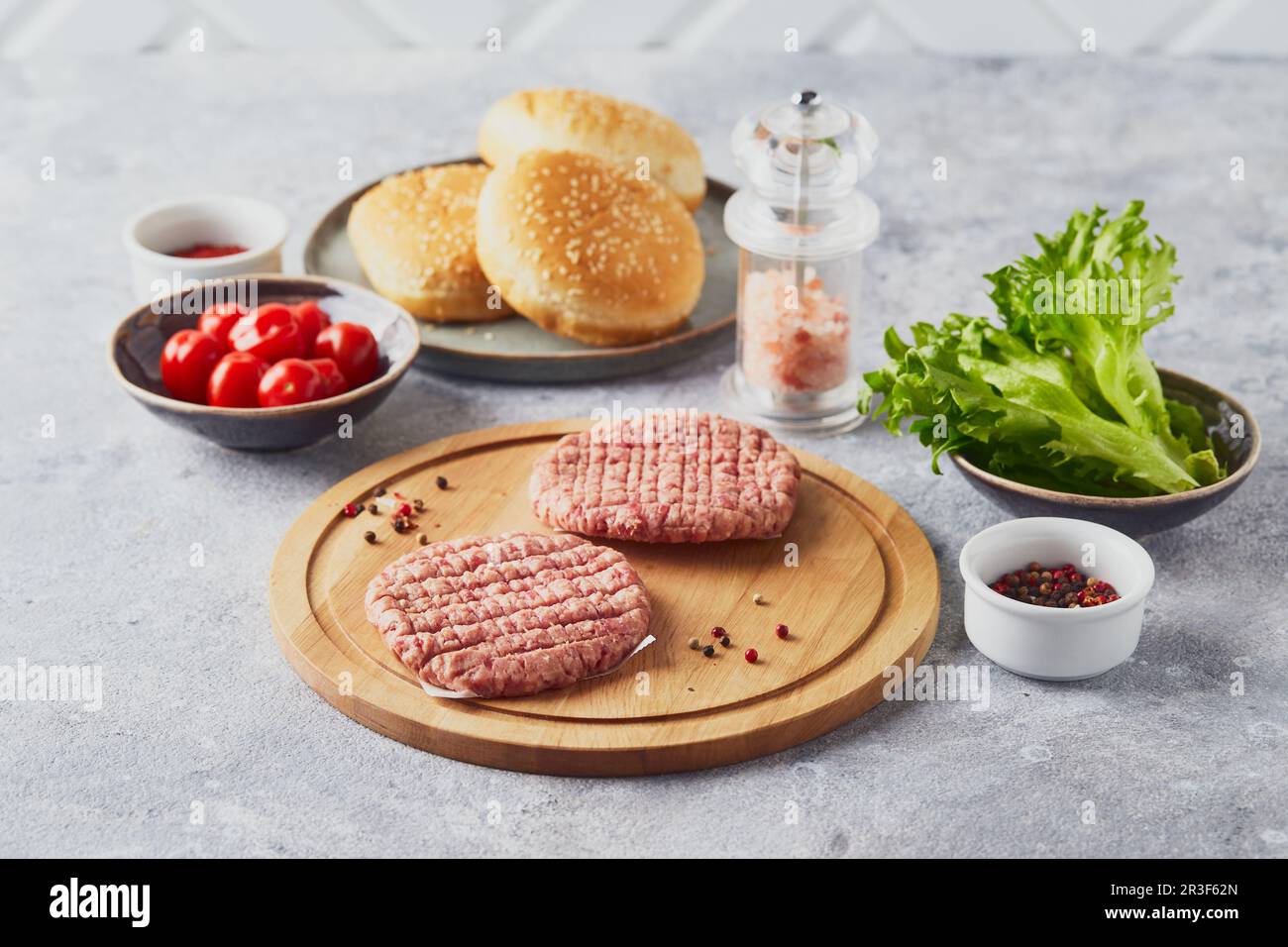 Cotolette di bistecca di vitello crudo al Burger su tagliere in legno Foto Stock