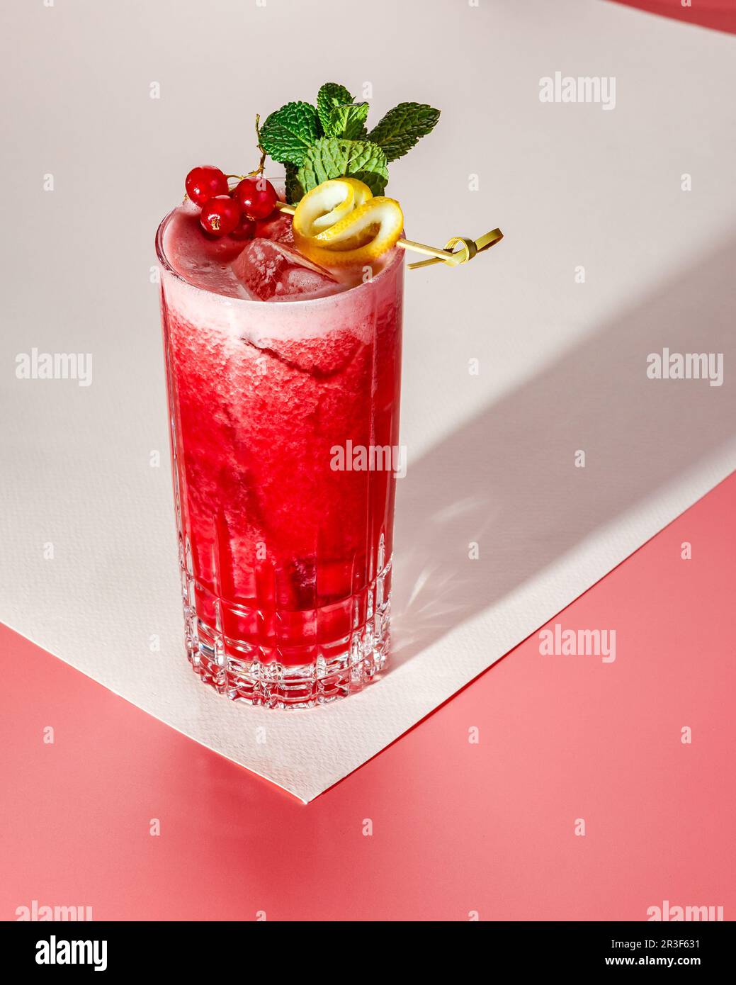 Cocktail alcolico o analcolico freddo su sfondo pastello. Luce dura, ombra profonda. Foto Stock