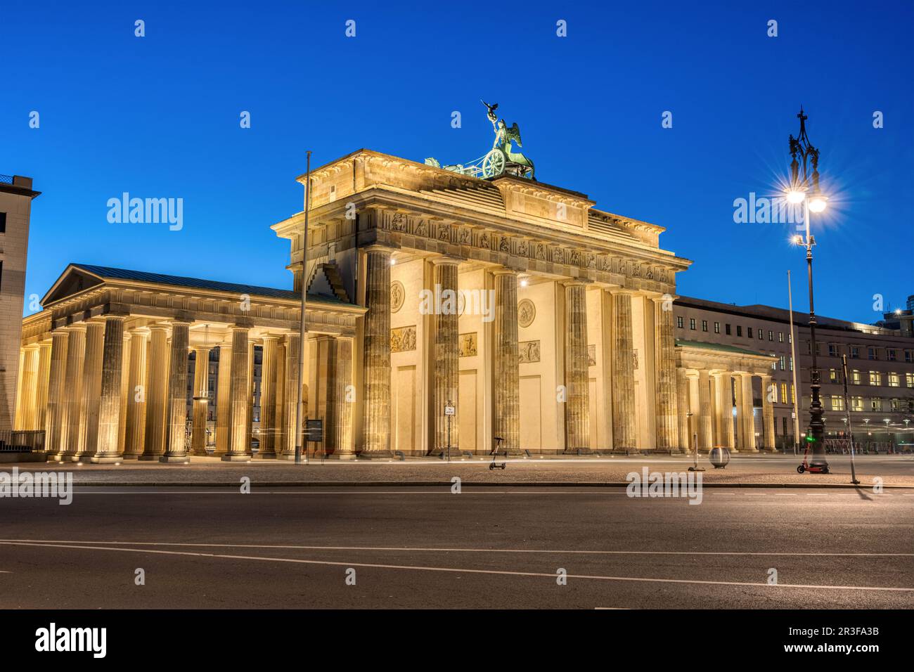 Il retro della porta di Brandeburgo illuminata a Berlino all'alba Foto Stock