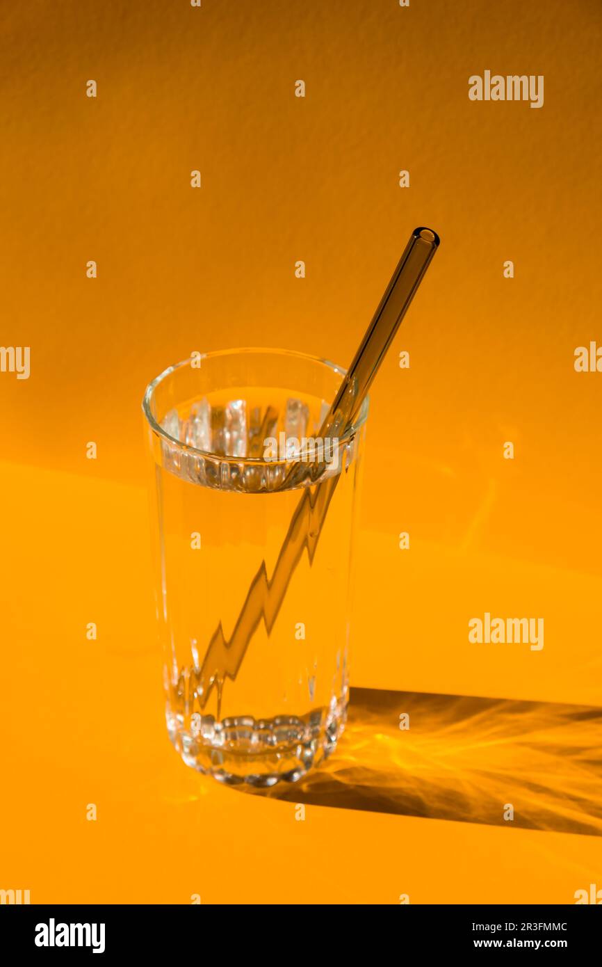 Cannucce in vetro riutilizzabili con acqua su sfondo giallo Set di cannucce per bevande ecocompatibili con spazzola di pulizia. Zero rifiuti, Foto Stock