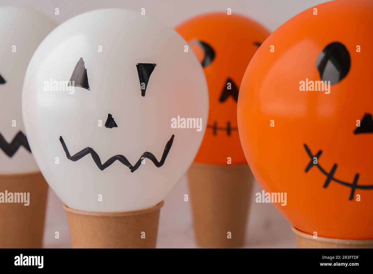 Le prese dipinte si affacciano sulle bollature. Preparazione di palle bianche e arancioni per la festa di Halloween. Attività domestiche di Halloween. Fatto a mano Foto Stock