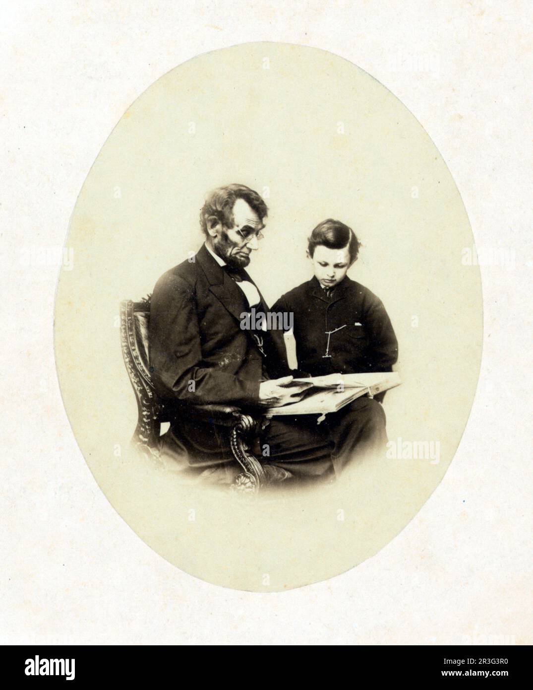 Abraham Lincoln, guardando un album fotografico con suo figlio, Tad Lincoln, 1864. Foto Stock