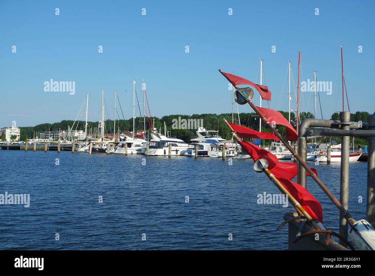 Boe da pesca con bandiere rosse nel paesaggio del porto Foto Stock