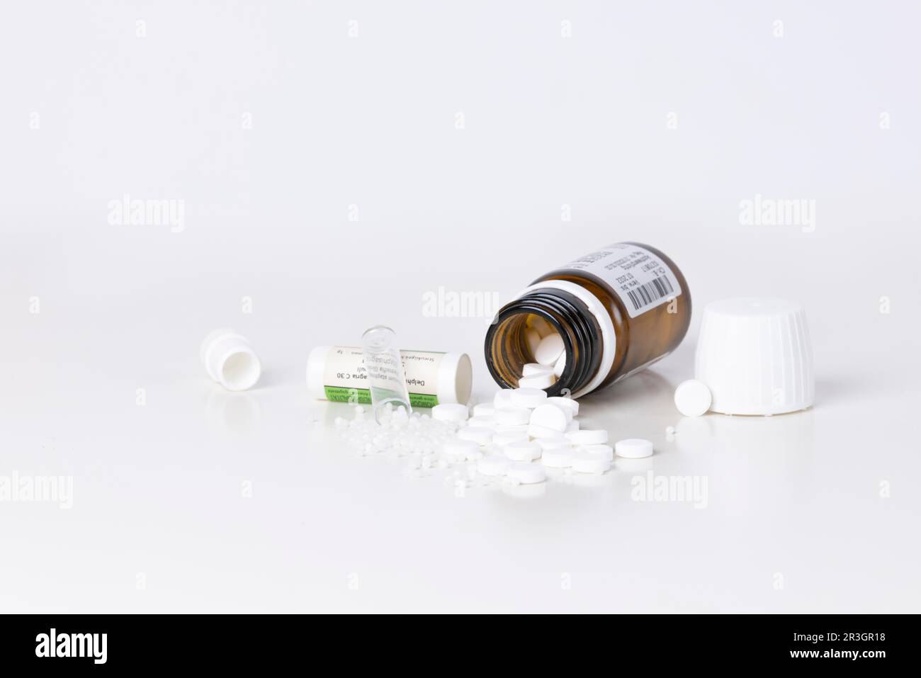 Rimedi omeopatici esauriti di contenitori, compresse e globuli, sfondo bianco, sala copia Foto Stock