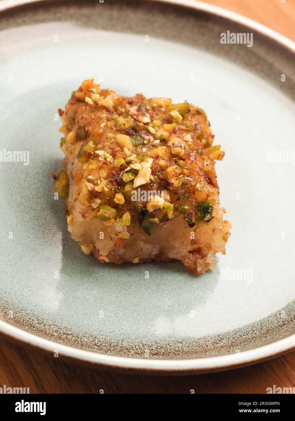 Torta di semola siriana con sciroppo di zucchero, gustoso Harisse su un piatto di ceramica blu, dessert siriano Foto Stock