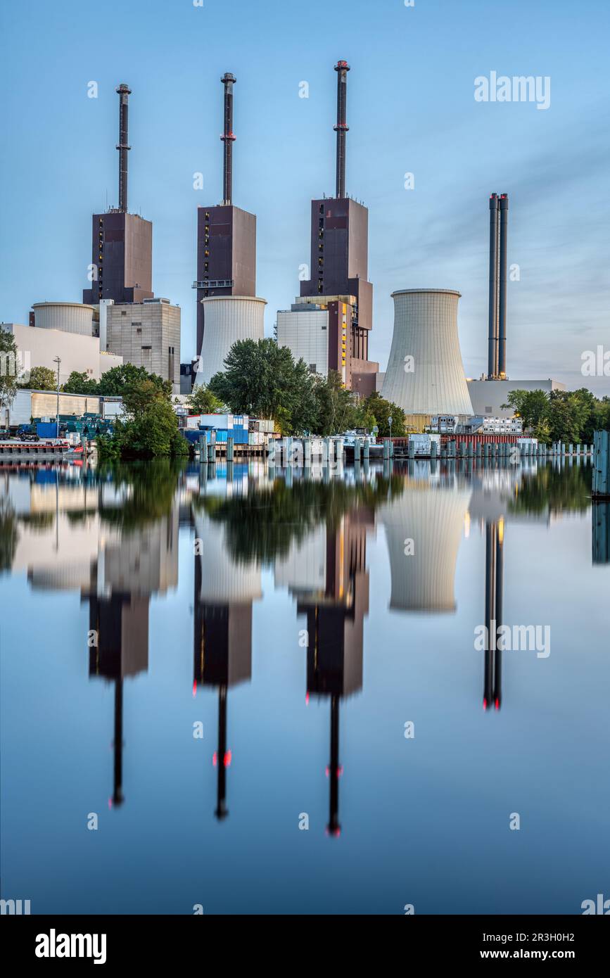 Una centrale termica a Berlino al crepuscolo riflessa in un canale Foto Stock