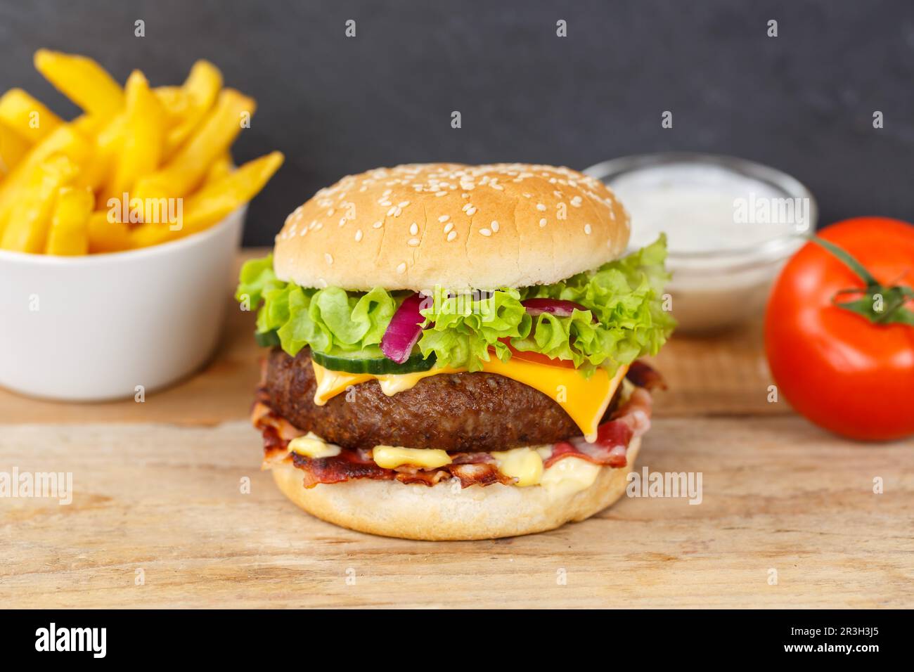 Hamburger cheeseburger menu fast food con patatine fritte su tavola di legno Foto Stock