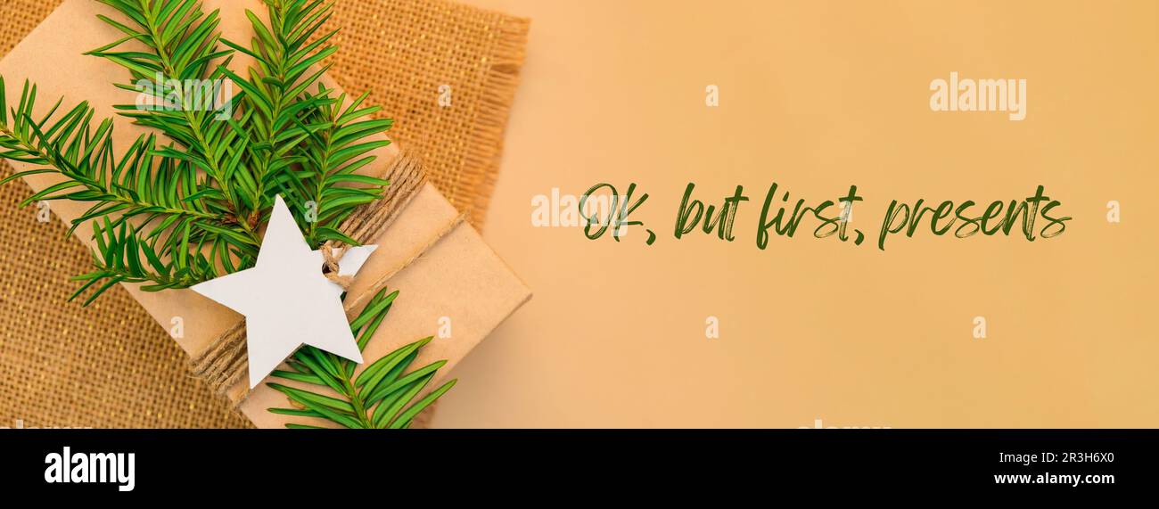 OK, ma in primo luogo, presenta l'ispirazione scherzo citazione frase Box con i regali di Capodanno, avvolto in carta artigianale e decorato con abete b Foto Stock
