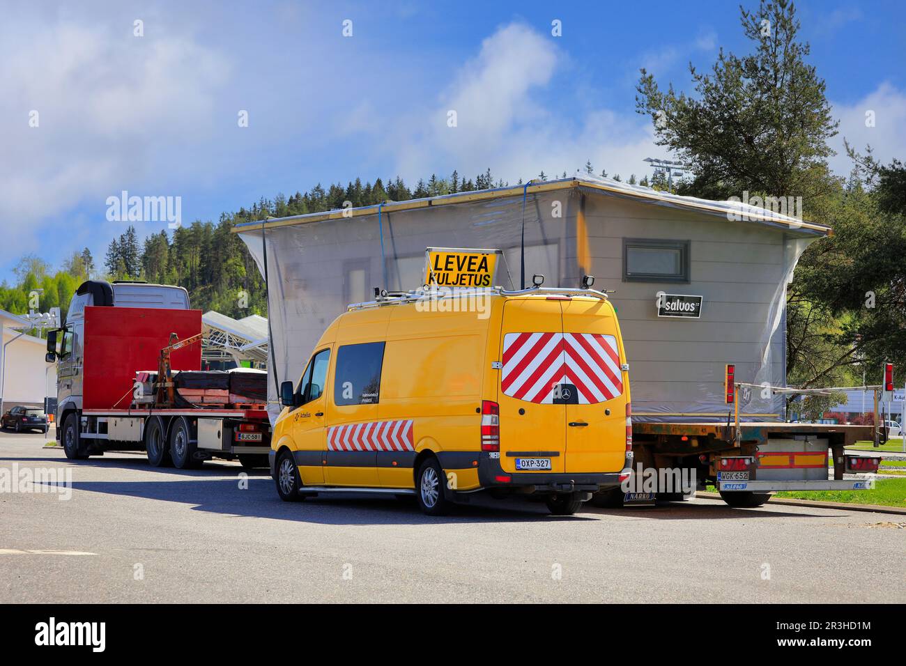 Autocarro che trasporta una cabina di tronchi Salvos come carico eccezionale parcheggiato sul piazzale di sosta con un veicolo pilota. Forssa, Finlandia. 19 maggio 2023. Foto Stock