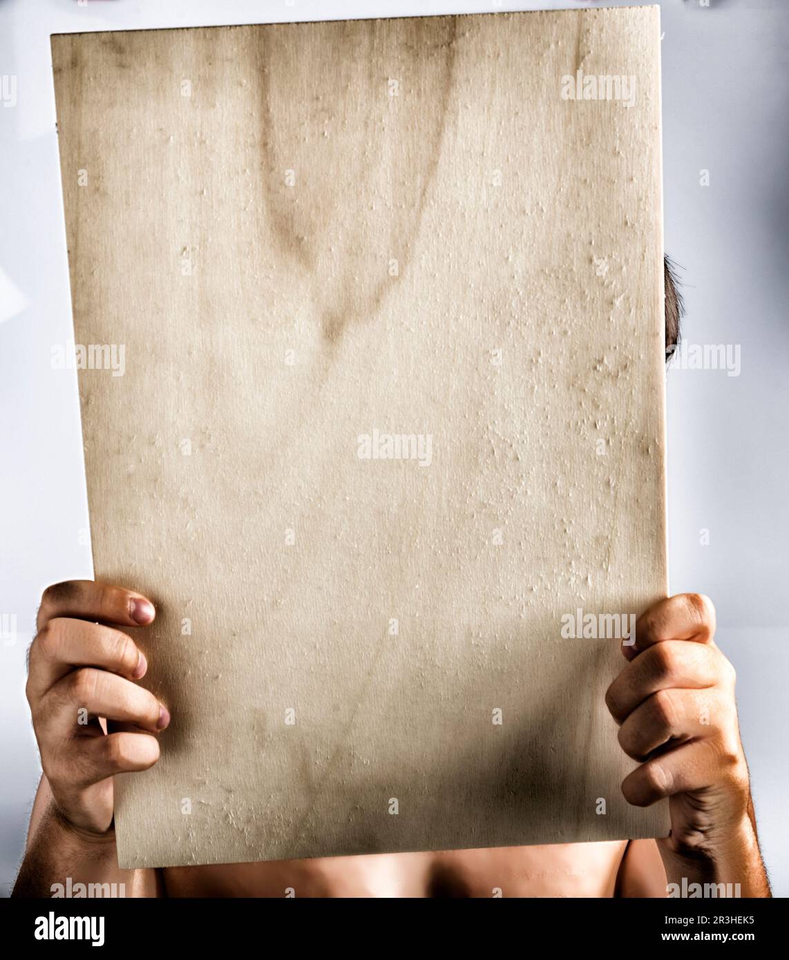 Legno compensato segno tenuto da mani giovani Foto Stock