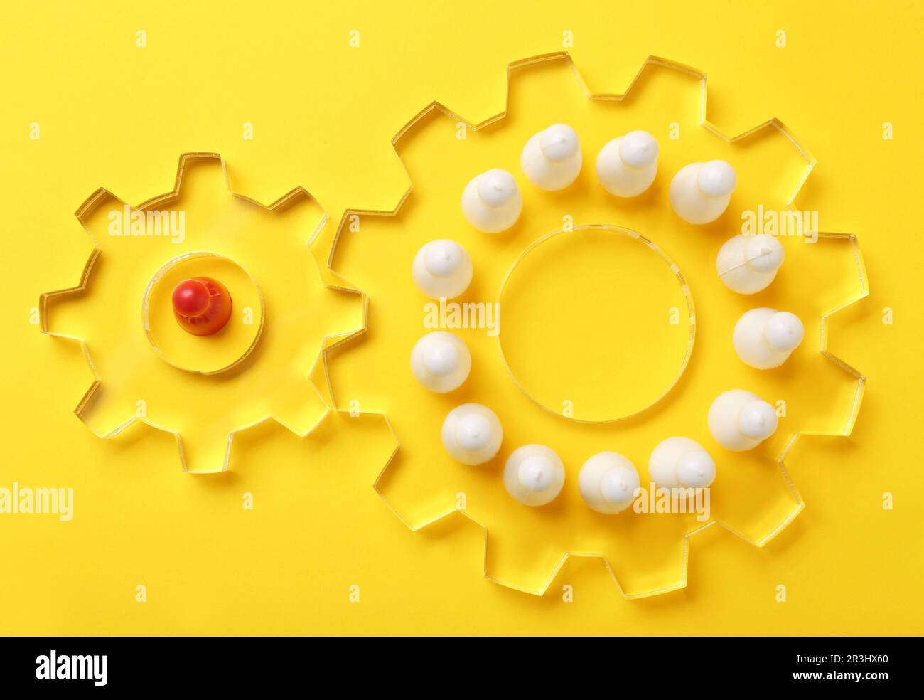 Processo di selezione dei dipendenti. Composizione piatta con ruote dentate, pedina rossa come recruiter e bianca come candidati su sfondo giallo Foto Stock