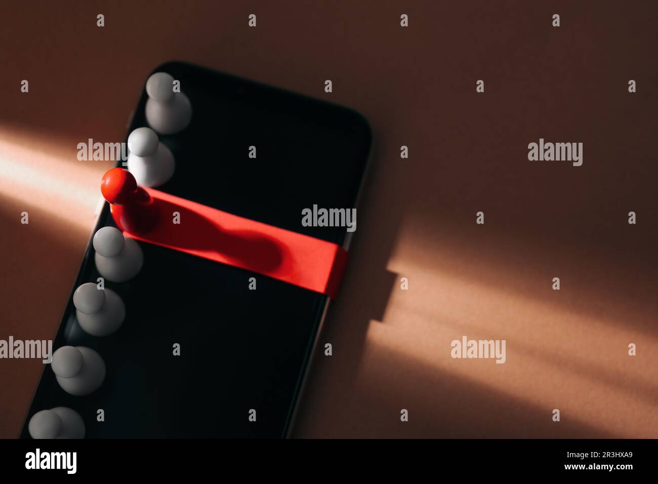 Processo di reclutamento, concetto di competizione di lavoro. Pedina rossa in fascio di luce come miglior candidato tra quelle bianche su sfondo marrone chiaro. Spazio per il testo Foto Stock