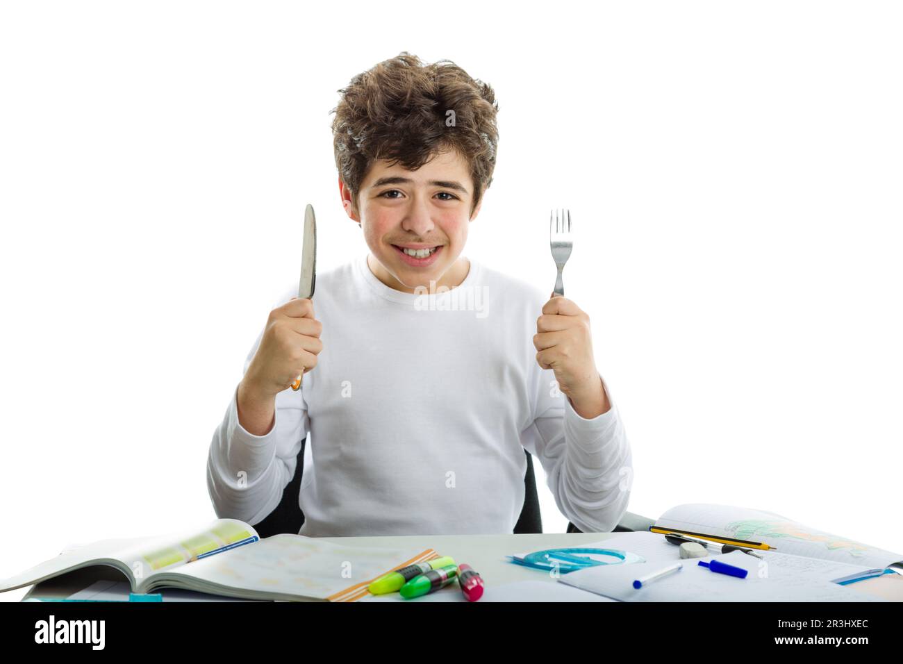 Ragazzo che fa i compiti con forchetta e coltello Foto Stock