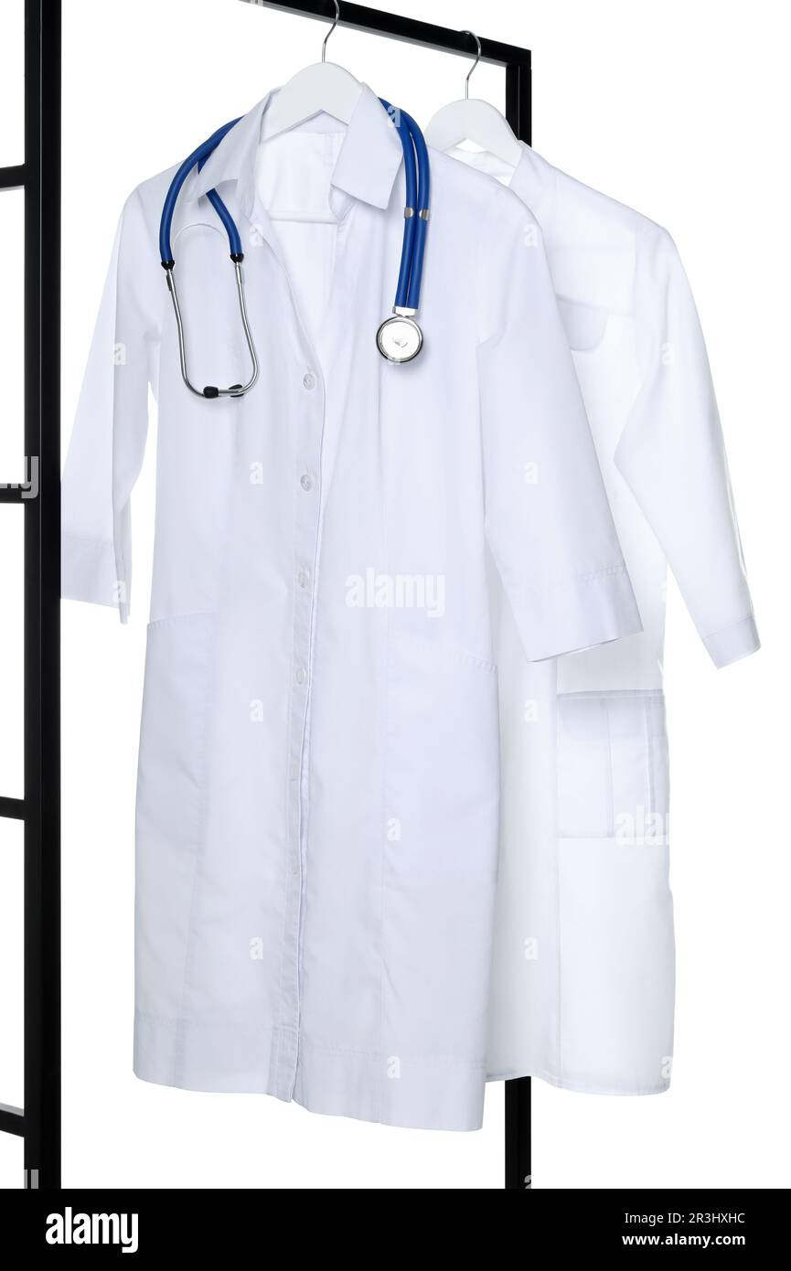 Camici da medico e stetoscopio su rack su sfondo bianco. Uniforme medica Foto Stock