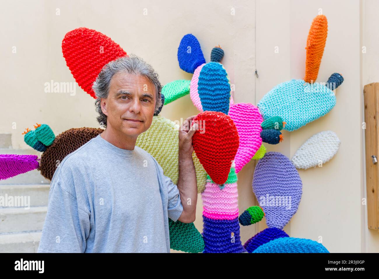 Uomo di mezza età vicino al cactus lavorato a maglia Foto Stock