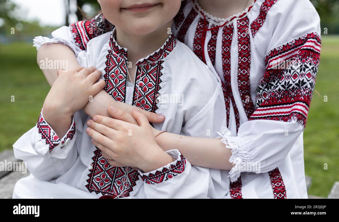 Le mani di due bambini, vestite con abiti tradizionali ucraini ricamati, si tengono in mano Foto Stock