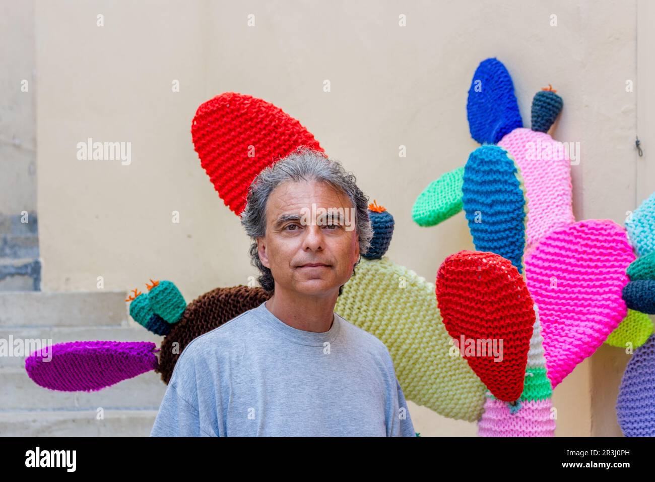 Uomo di mezza età vicino al cactus lavorato a maglia Foto Stock