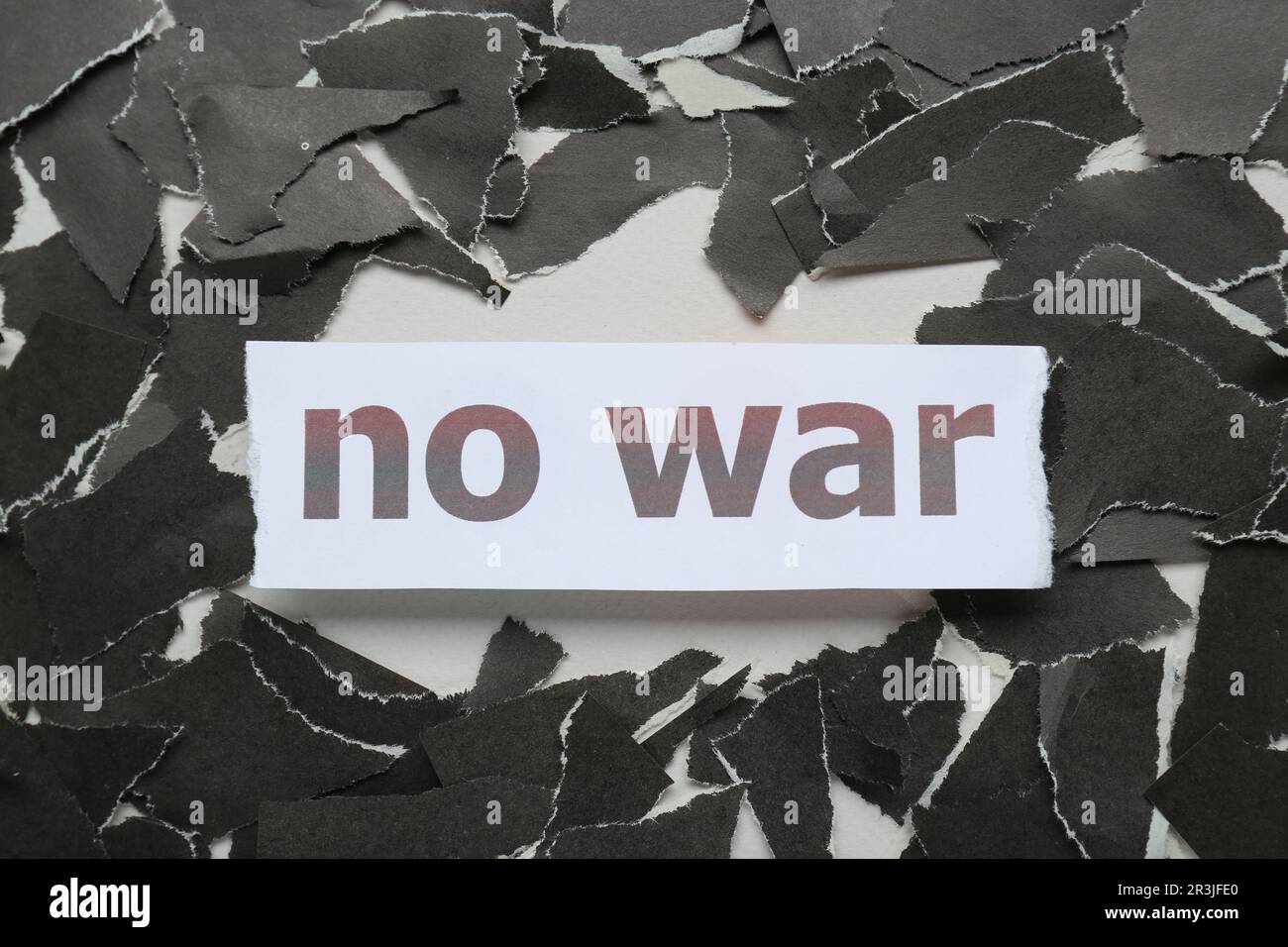 Parole Nessuna guerra e pezzi di carta nera strappata su sfondo bianco, piatto Foto Stock