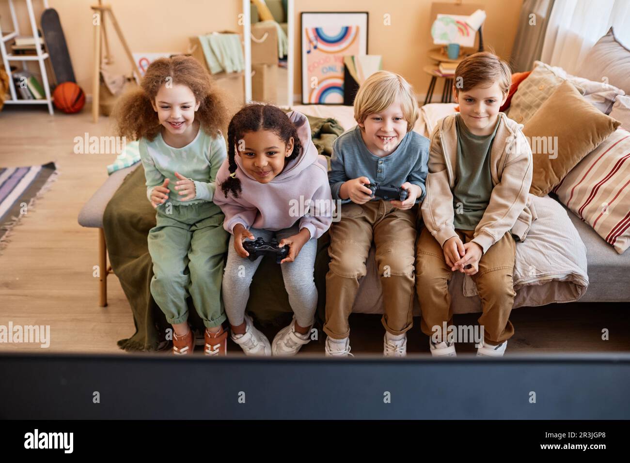 Vista ad angolo alto a gruppi di bambini che giocano insieme e si divertono Foto Stock