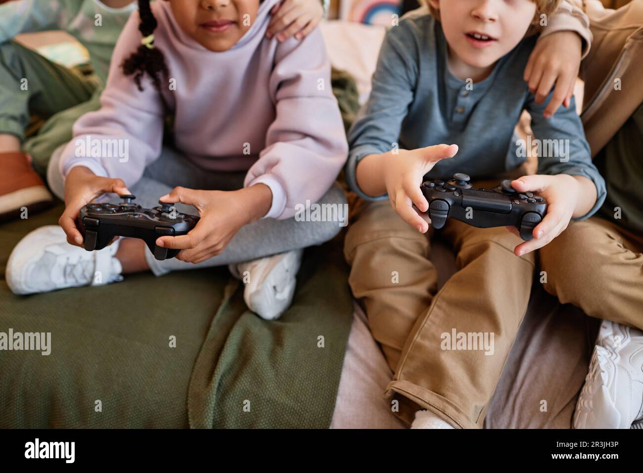 Primo piano dei bambini che giocano insieme ai videogiochi e che detengono controller Foto Stock
