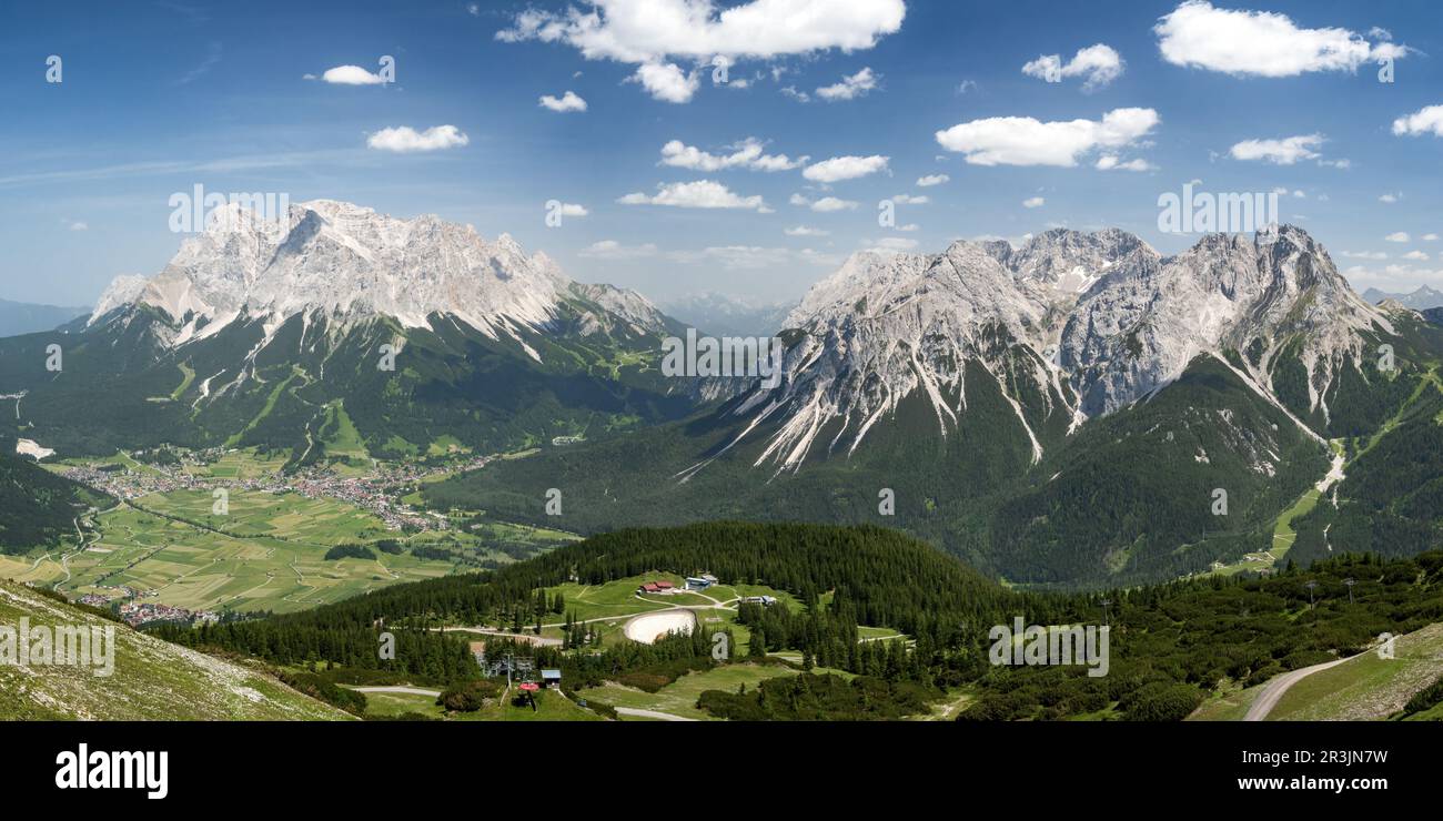 Montagne Zugspitze e Sonnenspitze. Città Ehrwald nella valle. Preso dalla funivia di Grubig Foto Stock