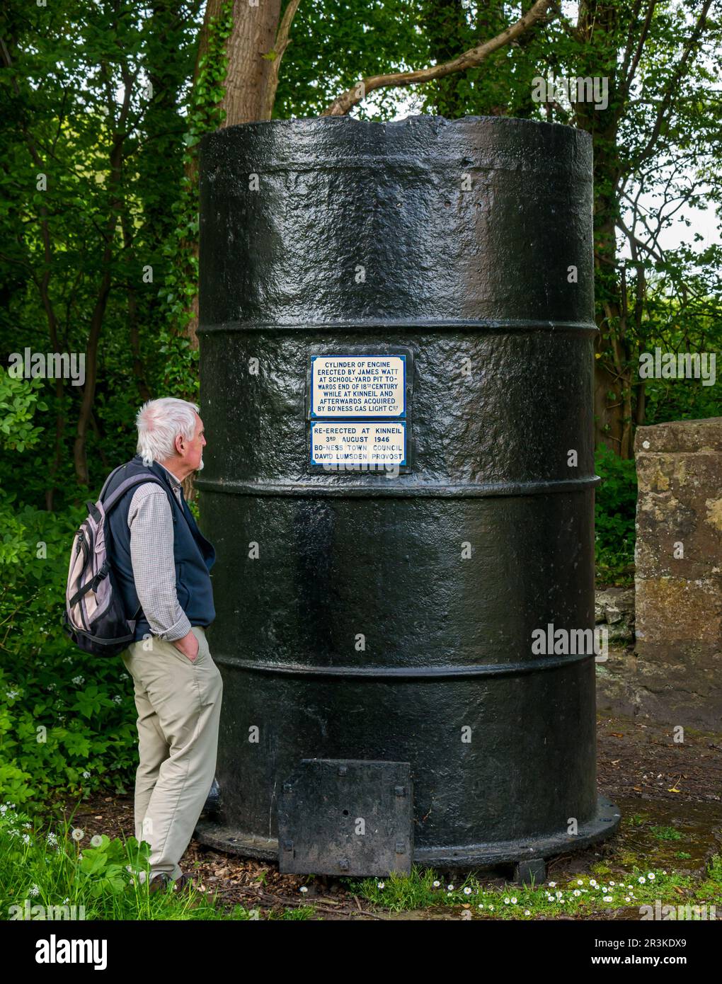 Uomo anziano che guarda le informazioni sul cilindro del motore James Watt esposto a Kinneil, Bo'Ness, Scozia, Regno Unito Foto Stock