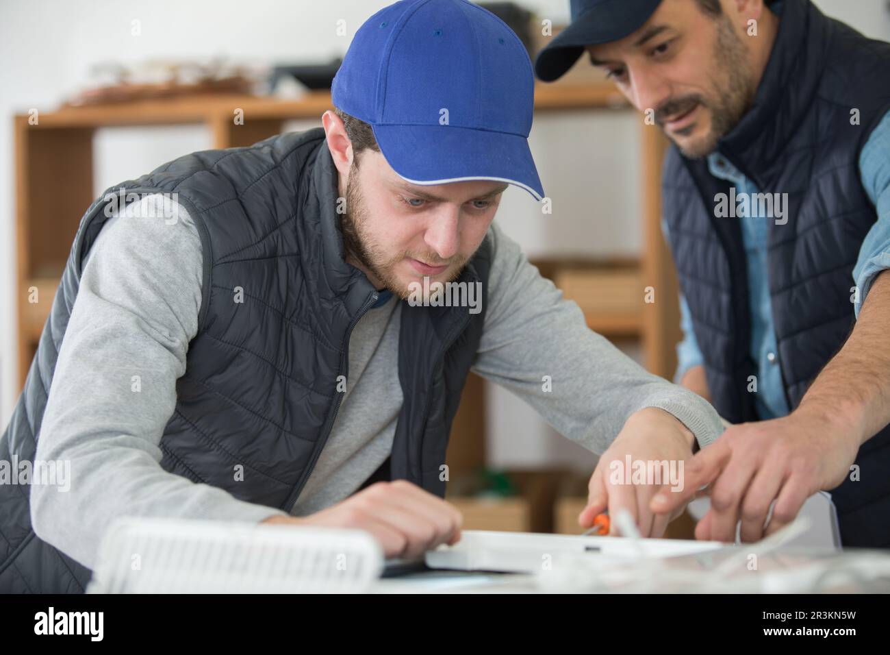 alto maestro artigiano falegname e apprendista Foto Stock