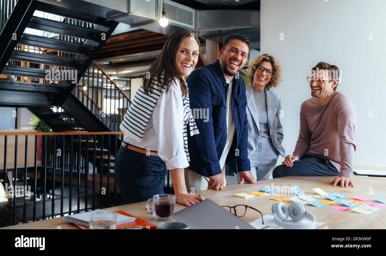 Professionisti della pubblicità che sorridono in una riunione. uomini d'affari che fanno brainstorming in un ufficio. Uomini d'affari felici che hanno idee diverse e d Foto Stock