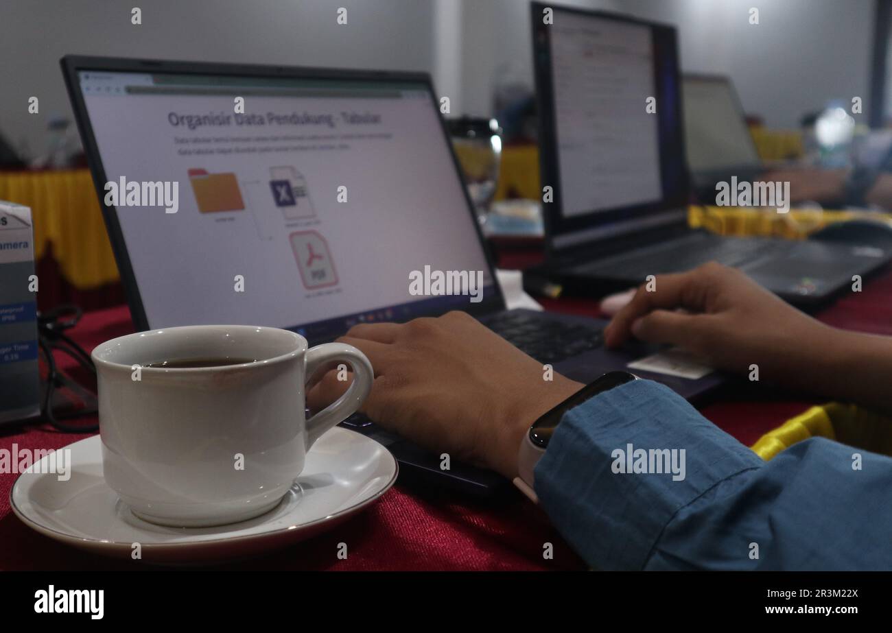 Vista ravvicinata della comoda scrivania con computer portatile, caffè e forniture per ufficio. Foto Stock