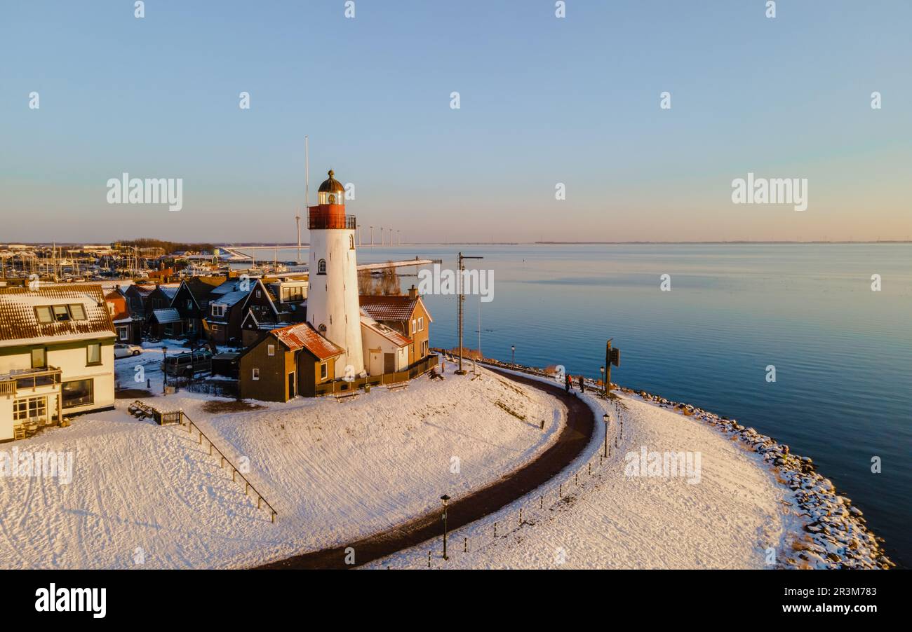 Faro di Urk durante l'inverno con la neve nei Paesi Bassi. Villaggio olandese in inverno Foto Stock