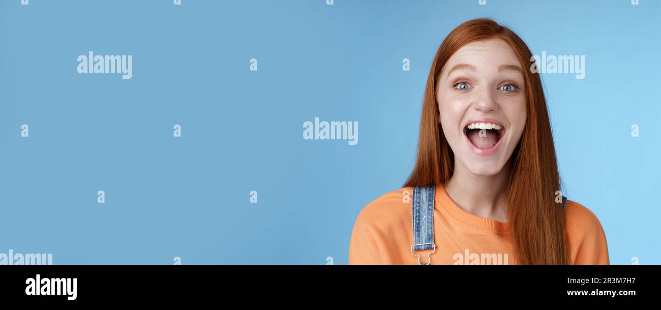 Divertente carismatico vivace ginger ragazza uscente entusiasta di divertirsi amici urlare dire un mostrando perfetto sorriso bianco godere di frien Foto Stock
