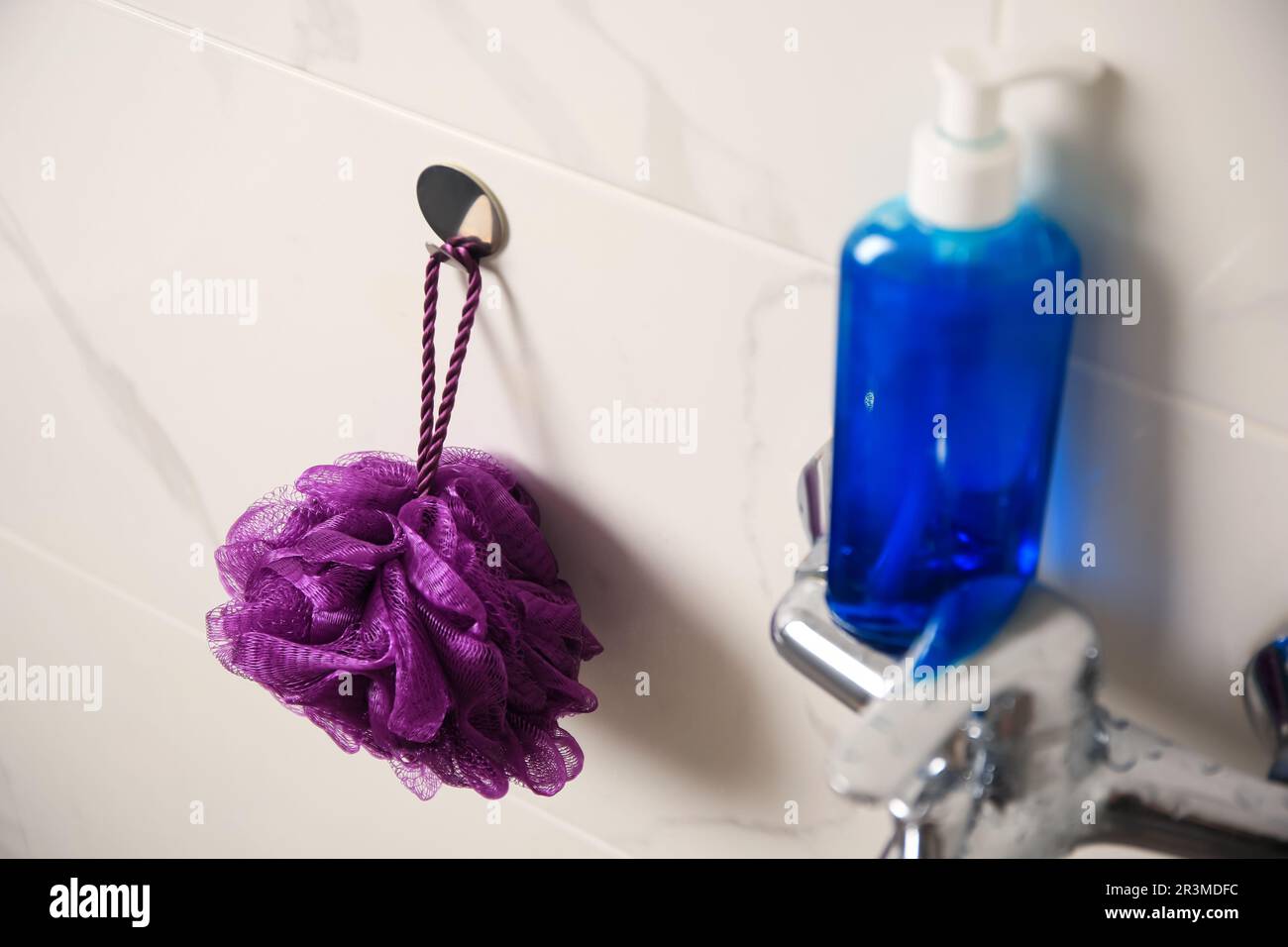 Doccia viola e bottiglia di gel per il lavaggio del corpo in bagno Foto Stock