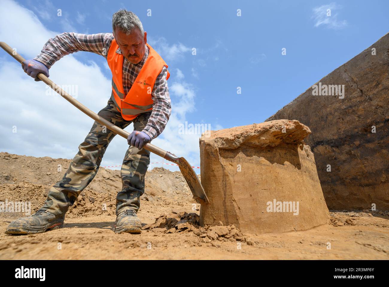 24 maggio 2023, Sassonia, Döbeln: Un dipendente dell'Ufficio di Archeologia della Sassonia lavora durante gli scavi nel cantiere del futuro Karls Erlebnisdorf. Dall'autunno del 2021, l'Ufficio di Archeologia della Sassonia ha condotto estesi scavi sul sito di 17 ettari del futuro villaggio avventura vicino a Döbeln. Con la sua ricchezza di reperti e dimensioni immense, il sito vicino a Döbeln-Gärtitz è uno dei più grandi siti di insediamento del primo Neolitico (5.500 - 4.500 a.C.) nella regione del loess del Medio Sassone conosciuta fino ad oggi. Foto: Robert Michael/dpa Foto Stock