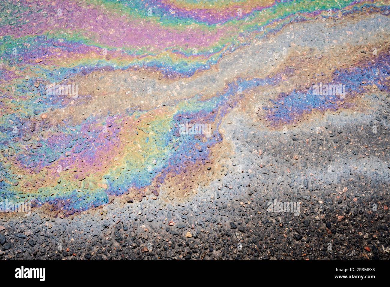 Macchie di olio su asfalto bagnato. Il concetto di inquinamento ambientale, fuoriuscite di petrolio e problemi ambientali. Foto Stock
