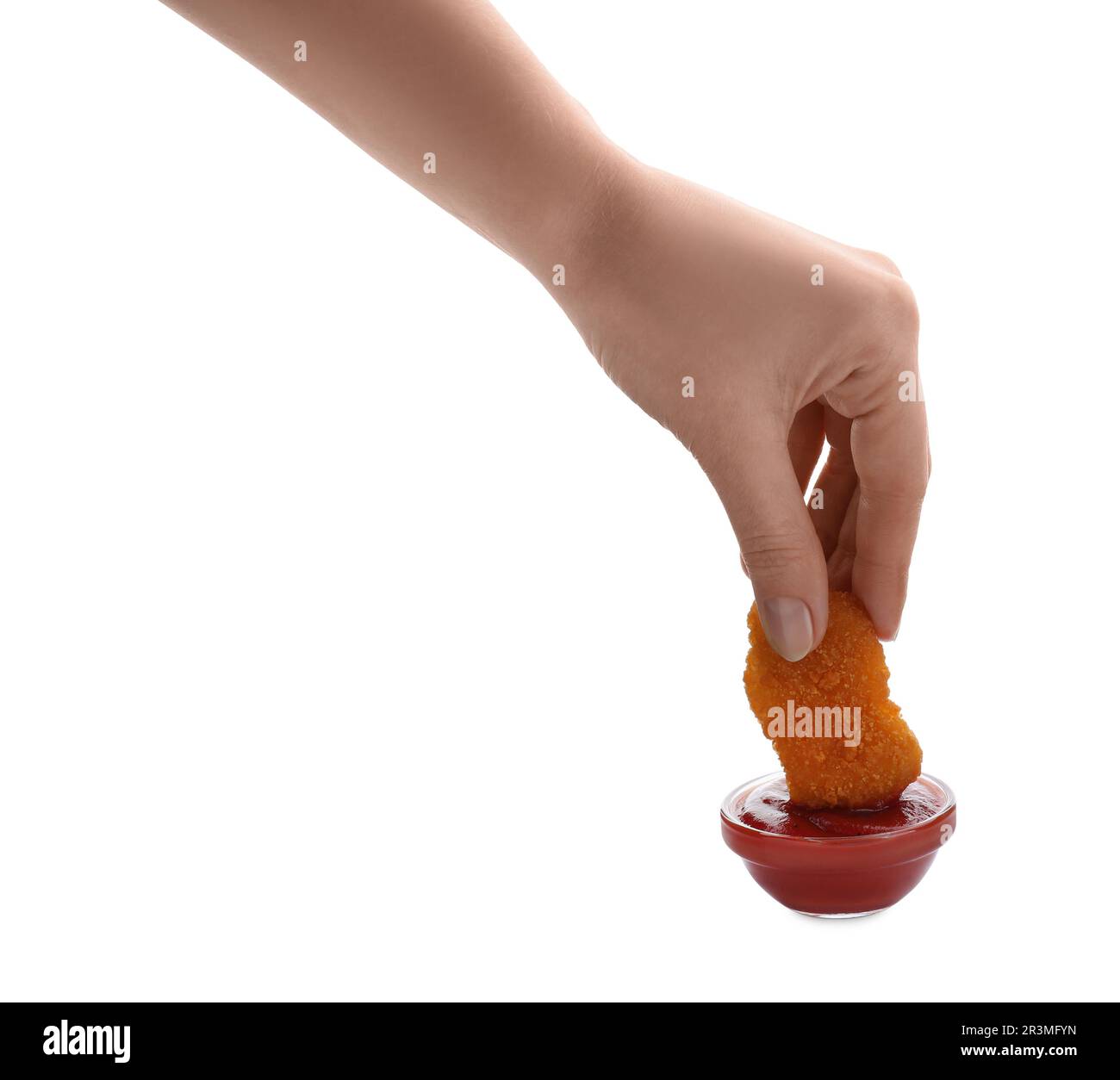 Donna che tuffa il nugget delizioso del pollo in ketchup su fondo bianco, primo piano Foto Stock