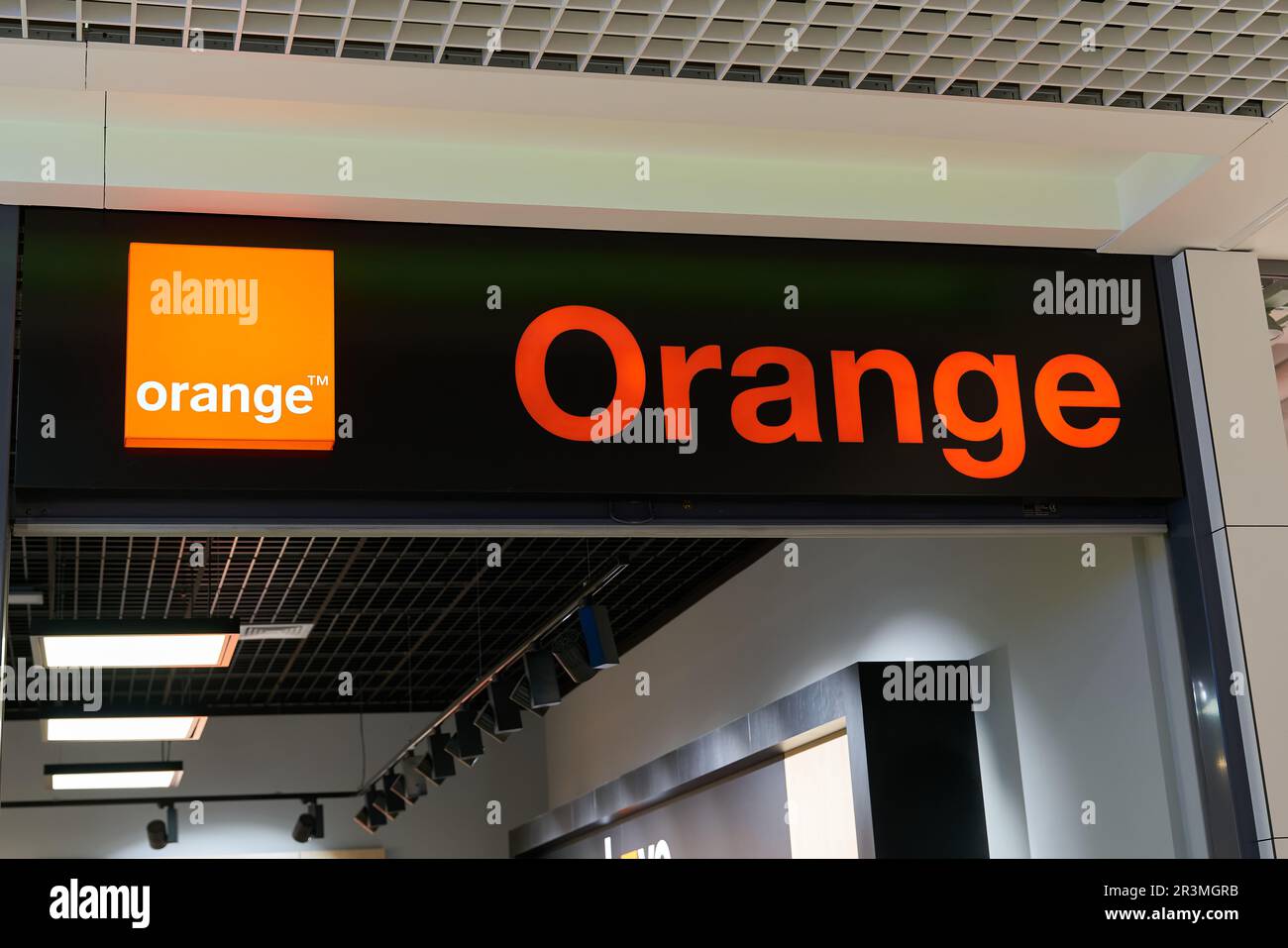 Insegna illuminata della società di telecomunicazioni francese Orange in un negozio in Polonia Foto Stock