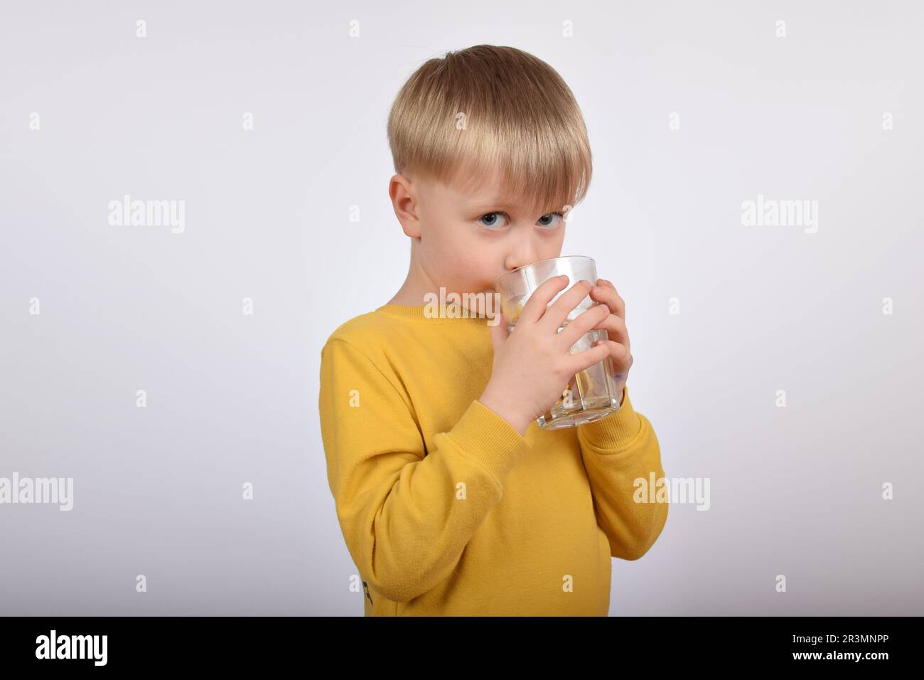 Giovane ragazzo che beve acqua pulita dal vetro Foto Stock