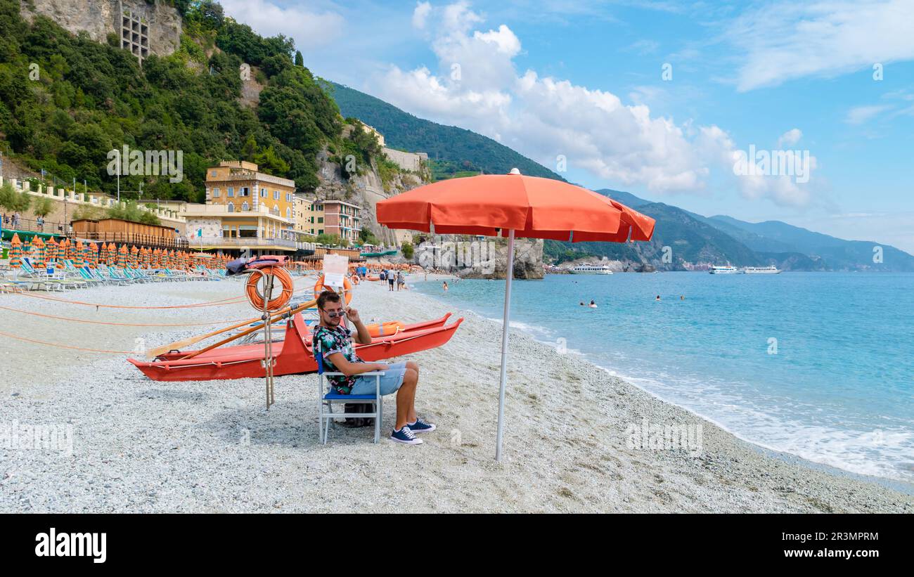 Spiaggia di ciottoli Monterosso vacanze Sedie e ombrelloni sulla spiaggia delle cinque Terre. Foto Stock