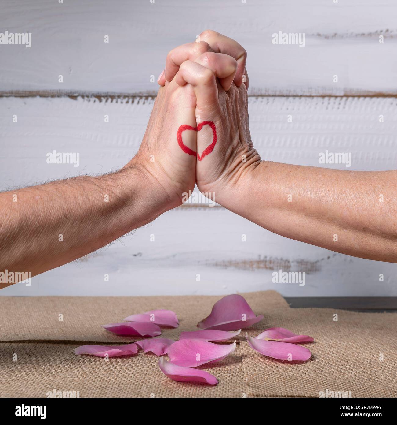 Una mano maschio e una femmina si uniscono per formare un disegno del cuore sul lato delle mani Foto Stock