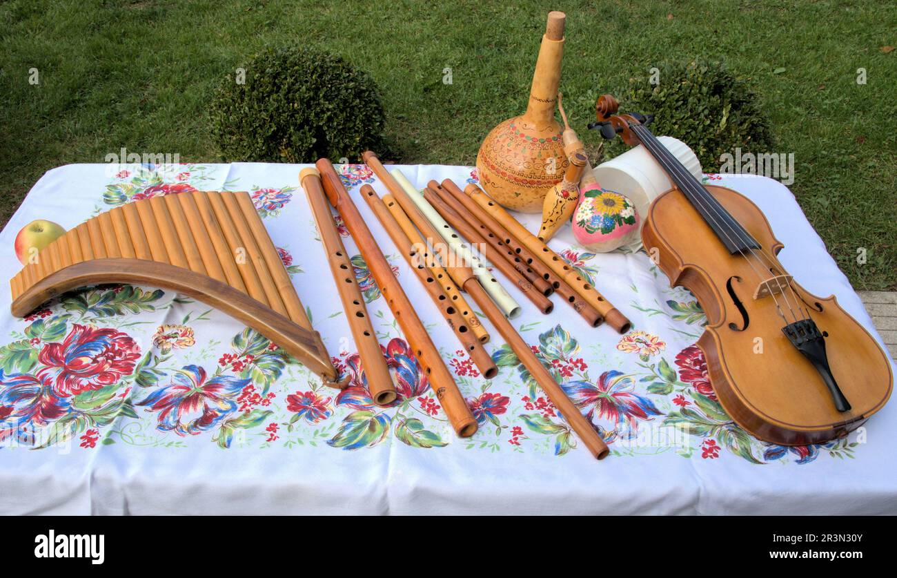Flauto di violino con strumenti folk in legno fatto a mano su tovaglia colorata con fiori Foto Stock